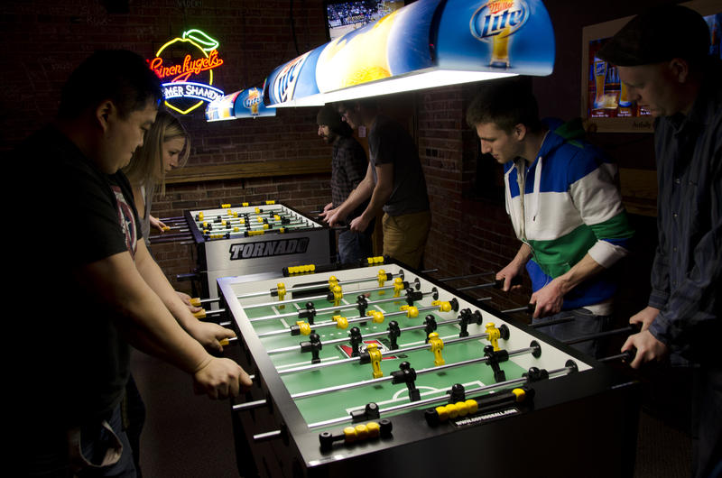 Football fans playing foosball